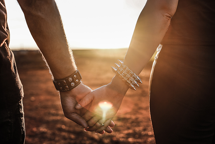 Two people holding hands in warm evening light
